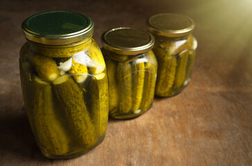Homemade cucumbers for the winter. Pickled cucumbers of own preparation. Pickles in glass jars on the table.