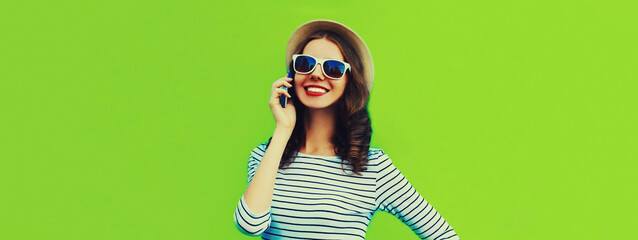 Portrait of happy smiling young woman calling on smartphone on green background, blank copy space for advertising text