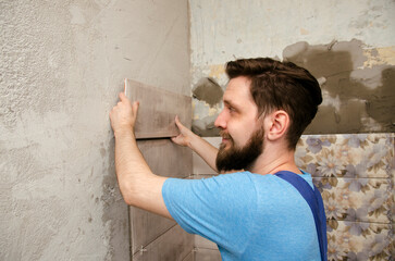 Obraz na płótnie Canvas Man gluing tiles in the bathroom, closeup shot 