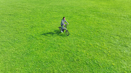 草原を自転車で走る女性