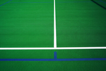 A Tennis Court has been marked off with blue tape for pickleball.     