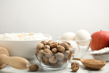 Nutmeg seeds and other ingredients for pastry on white marble table