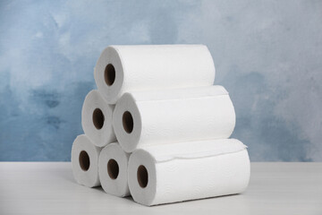 Many rolls of paper towels on white wooden table