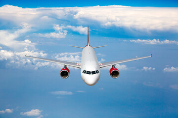 White passenger plane with red engines in flight. Front view.
