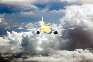 Yellow passenger jet plane in the sky. Airplane flies high through the clouds. Front view of aircraft.
