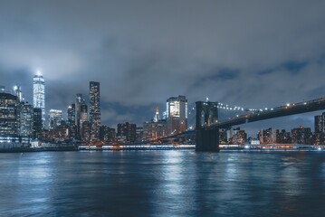 Obraz na płótnie Canvas Brooklyn Bridge at Night with Water Reflection in New York City