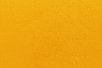 Gold or yellow paint on cement wall texture  background.