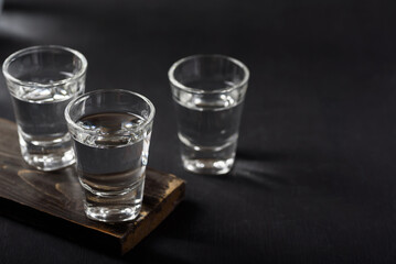 Vodka in a shot glass on black background