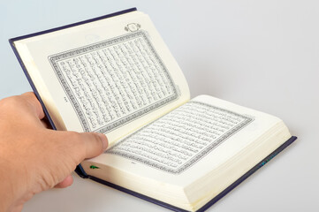Holy Al Quran with written in arabic calligraphy isolated on a white background