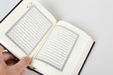 Holy Al Quran with written in arabic calligraphy isolated on a white background