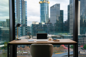 Office desk with view of skyscraper in modern city - 507721206