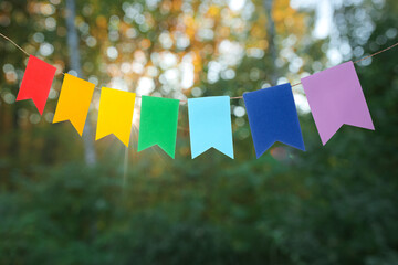 Colorful festive bunting flags in green park - obrazy, fototapety, plakaty