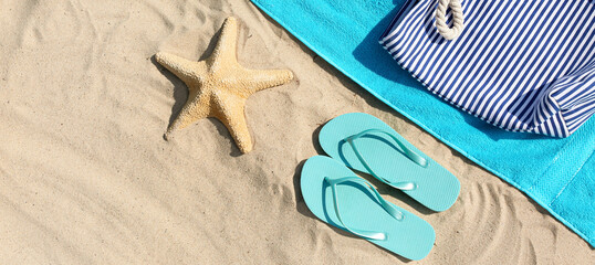 Fototapeta na wymiar Flip-flops, beach bag, towel and starfish on sand