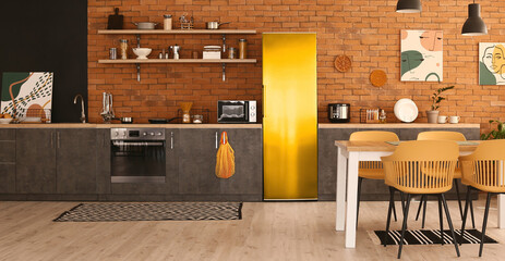 Stylish interior of modern kitchen with yellow fridge and brick wall