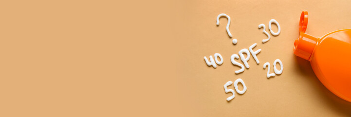 Bottle of sunscreen on beige background with space for text
