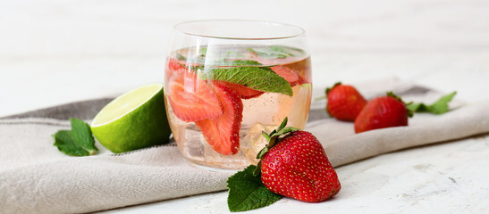 Glass of tasty strawberry mojito on light table