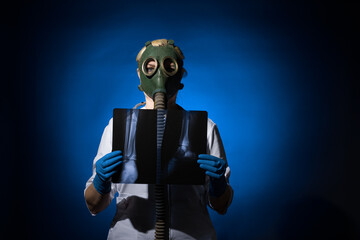 doctor woman in gas mask and gloves holding x-rays on blue background