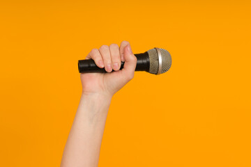 Fototapeta na wymiar microphone in hand on a colored background