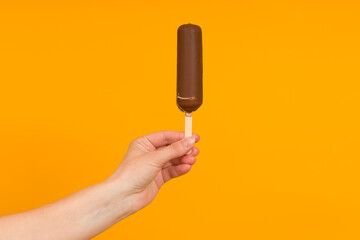woman holding ice cream on a stick in her hand, colored background