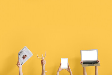 People with newspaper, gadgets and wooden mannequin on yellow background