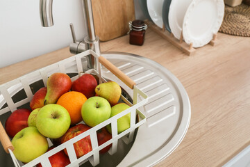 Basket with fresh fruits in sink, closeup