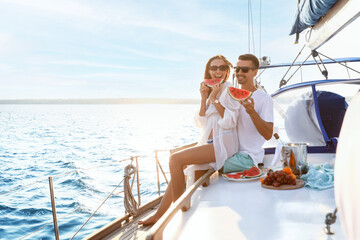 Happy young couple resting on yacht - obrazy, fototapety, plakaty