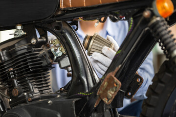 Obraz premium Man checking air filter, Mechanic repairing motorcycle in repair shop, Man repair motorbike in garage, mechanic fixing motorcycle engine