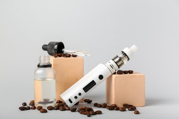 Modern vape mod, oil and coffee beans on grey background
