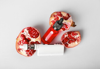 Modern vape mod, oil and pomegranate on grey background