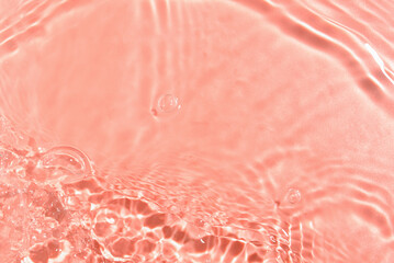 Texture of water with ripples on pink background, closeup
