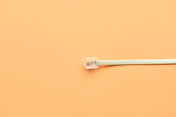 White internet cable on orange background, closeup