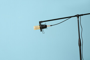 Stand with modern professional microphone on color background