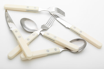 Set of stainless steel cutlery with plastic handle on white background