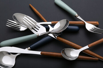 Different stainless steel cutlery on black background