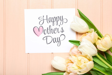 Card with text HAPPY MOTHER'S DAY and flowers on pink wooden background