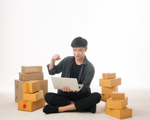 Experienced businessman at work. Portrait of a businessman next to a laptop. Man asian is engaged in some kind of business. He holds boxes in his hands. Concept - it fills in information for shipping 