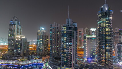 Fototapeta na wymiar Dubai Marina luxury tourist district with skyscrapers and towers around canal aerial night timelapse