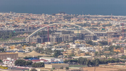 Construction site around Dubai water canal with pedestrian bridge over it aerial timelapse.