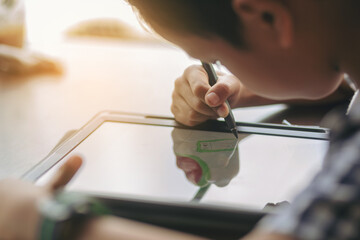 Boy with digital pencil drawing and painting on a tablet at home to develop the skills of children in the digital age. Selected focus