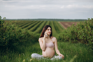 Caucasian pregnant woman talking on the smart phone.