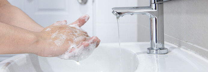 Men are washing their hands in the sinks to clear respiratory bacteria and viruses, sanitation and...