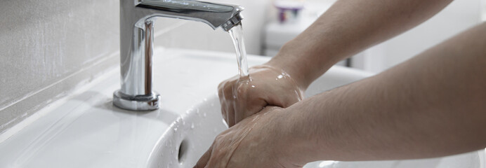 Men are washing their hands in the sinks to clear respiratory bacteria and viruses, sanitation and reduce the spread of COVID-19 that is spread around the world, Hygiene ,Sanitation concept.