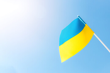 Large bicolor yellow blue Ukrainian state flag, national symbol fluttering, waving in wind against blue sky on sunny day. Kyiv city, capital of Ukraine, Independence Constitution Day, National holiday