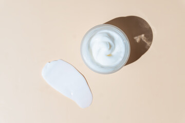 White cosmetic cream strokes on beige background. Skincare lotion face serum smear. Beauty product...