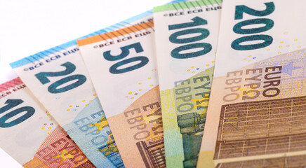 Euro banknotes of various denominations on a white background
