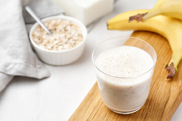 Milk cocktail with banana and oat. Banana smoothie. Milkshake with banana and oatmeal, healthy breakfast.