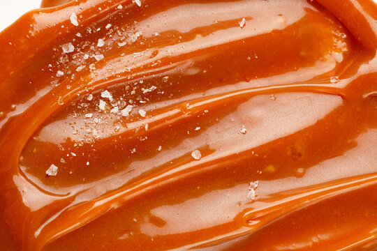 Liquid salted caramel syrup. Background of salted caramel paste. Texture Close up, top view.