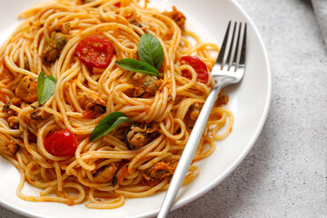 Seafood pasta  with mussels, tomatoes, basil in white plate