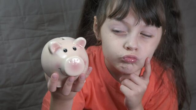 Child think about money. A young child think about piggy bank finance and future money in the room.