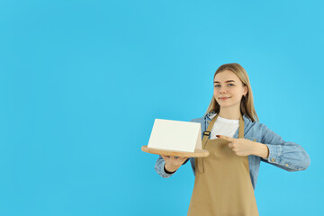 Concept of occupation, young female waiter on blue background